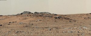 This Mars scene combines seven images NASA's Mars rover Curiosity. A rise topped by two gray rocks near the center of the scene is informally named "Twin Cairns Island." 